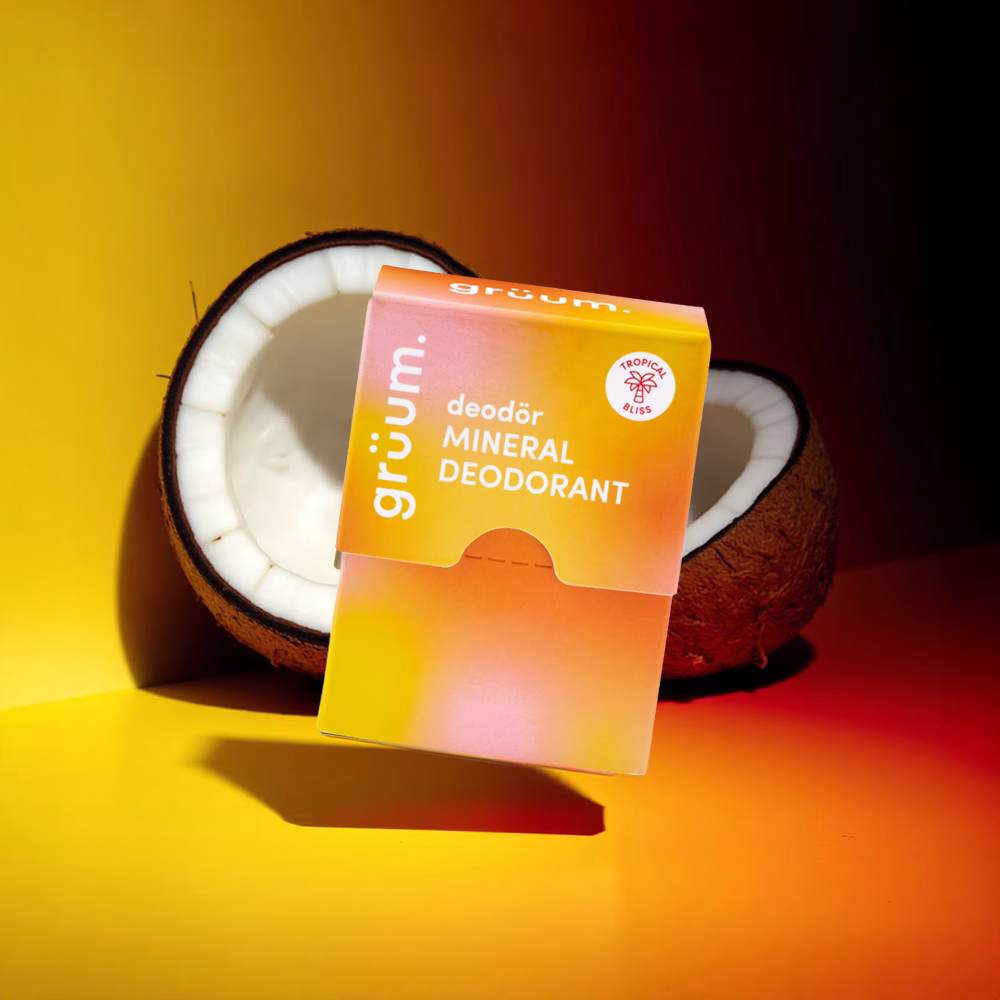 Deodorant package beside coconut.