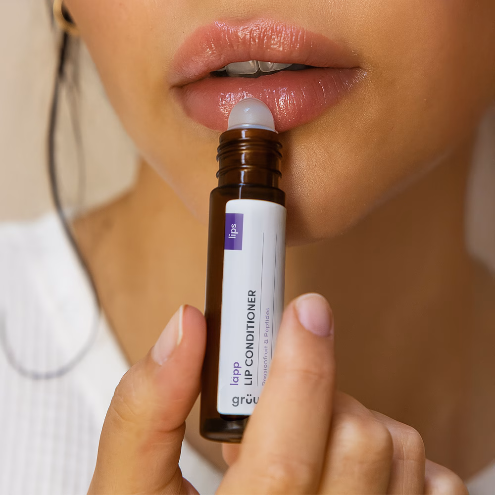 Applying lip conditioner to lips