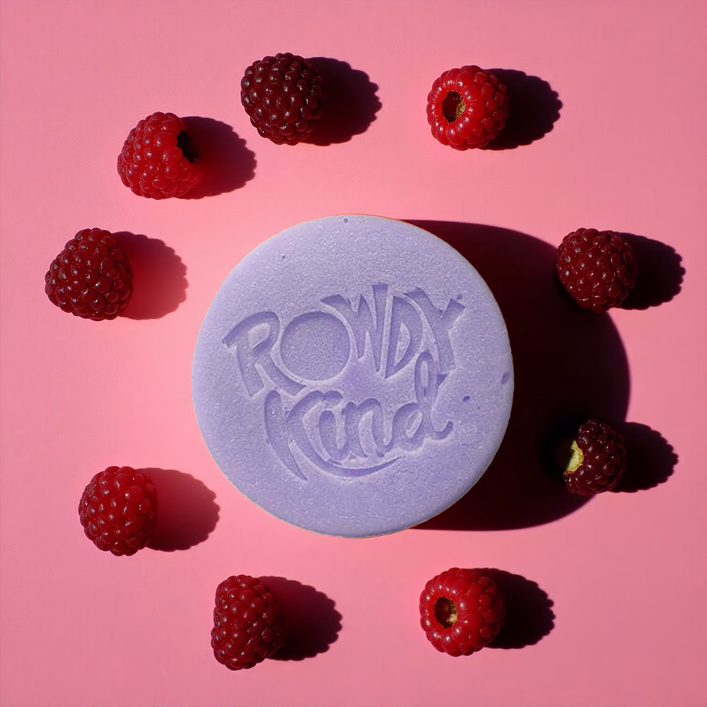 Purple soap surrounded by raspberries