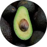 Sliced avocado among whole avocados