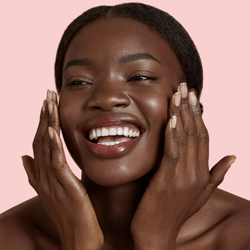 Smiling woman touching her face