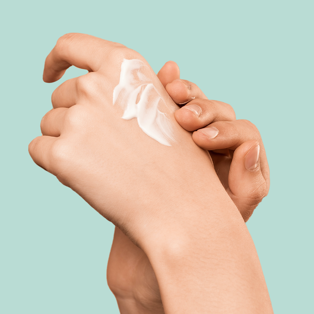 Hands applying lotion