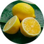 Whole and sliced lemon on leaf.