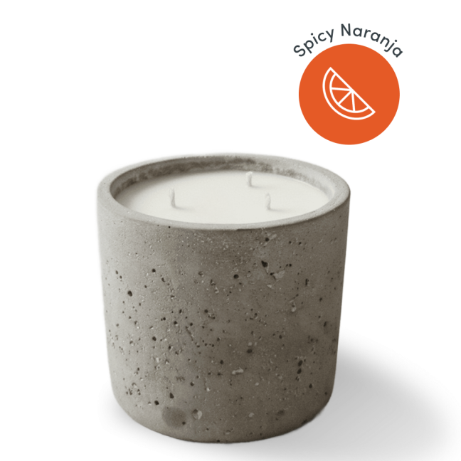 Concrete candle with orange label.