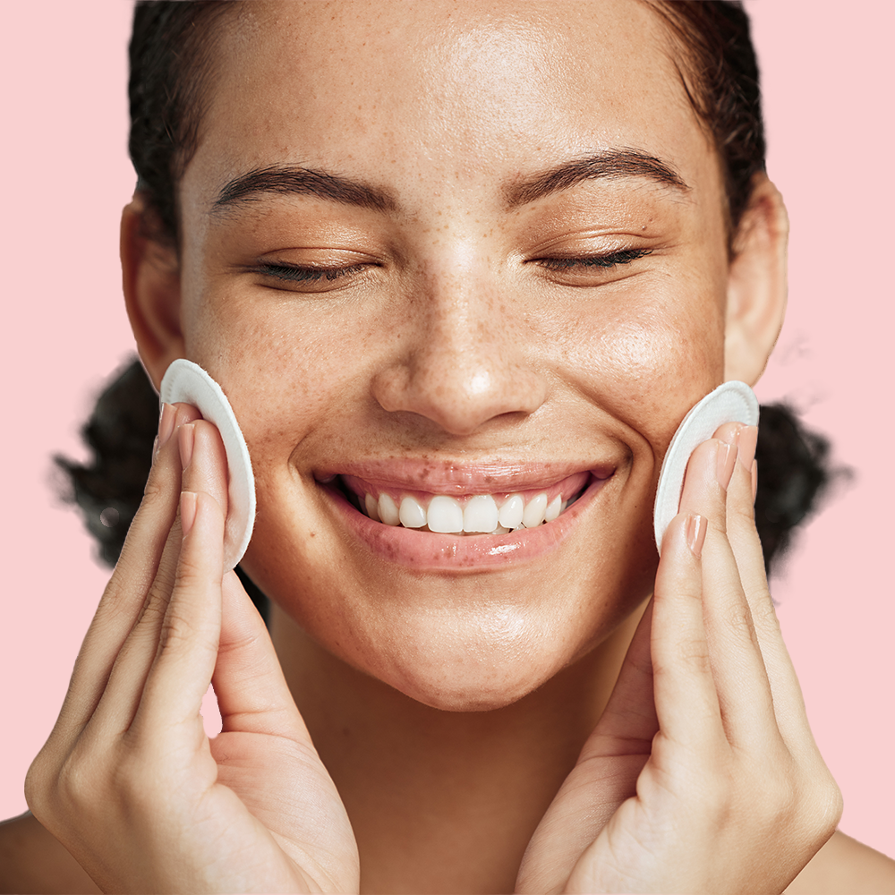 Smiling person with cotton pads on cheeks