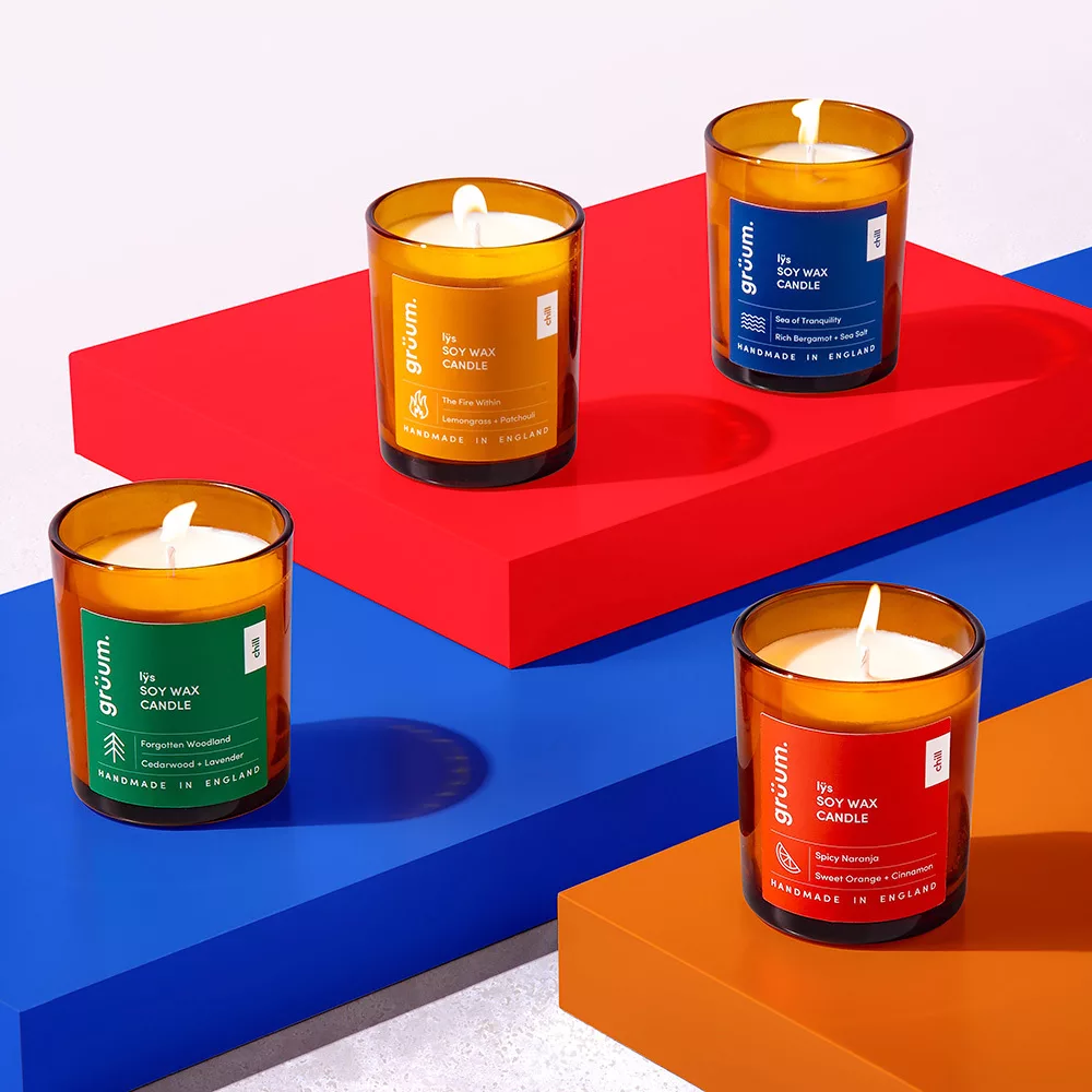 Four scented candles on colorful blocks.