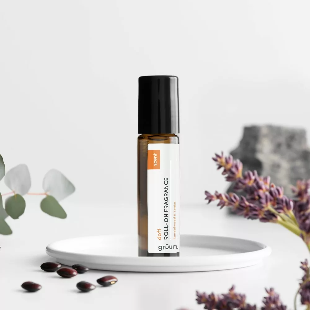 Roll-on fragrance bottle with plants nearby.