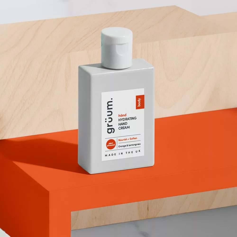 Hydrating hand cream on orange surface.