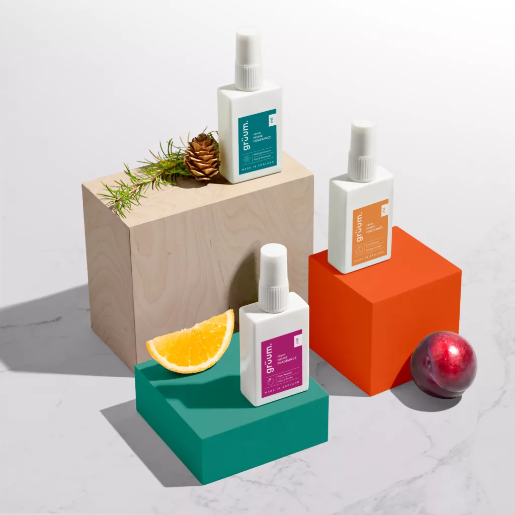 Three fragrance bottles on colorful blocks.