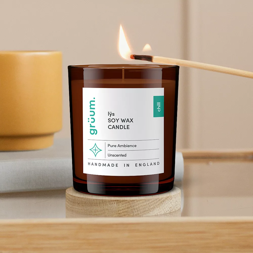 Lit soy wax candle on table.