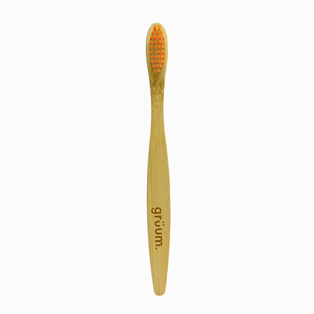Bamboo toothbrush with orange bristles.