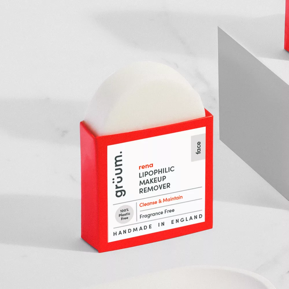 Red makeup remover packaging on marble surface.
