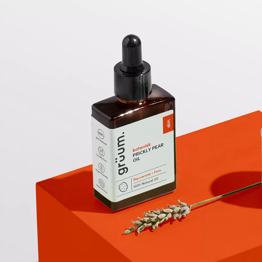 Prickly pear oil bottle on orange surface.