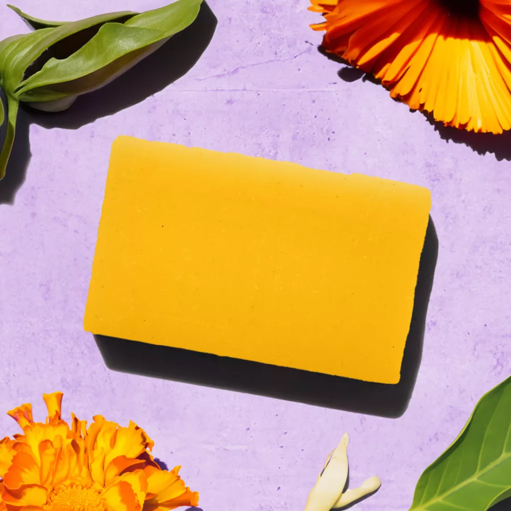 Yellow soap with flowers on purple background